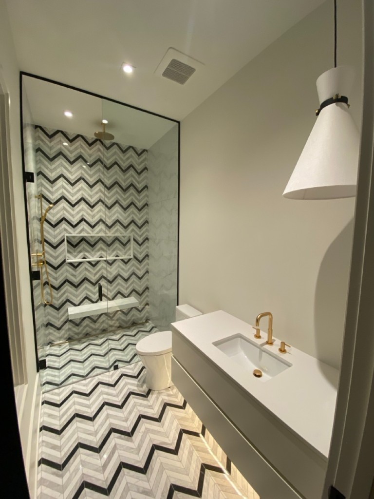 Chevron-tile ensuite with black-trim frameless glass shower